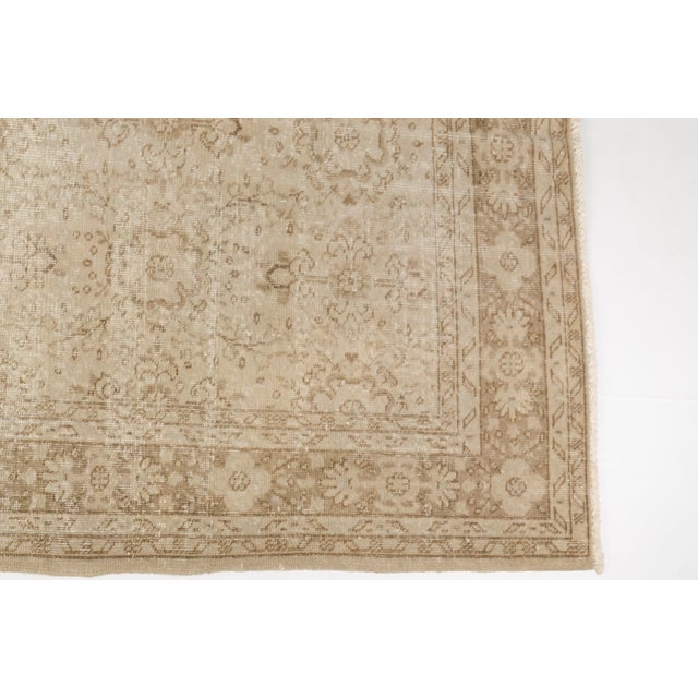 This is a vintage Turkish Oushak rug from the Mid 20th Century. The piece was hand-knotted.