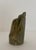 Hand carved stone sculpture with shades of green, brown and tan. Artist signed.