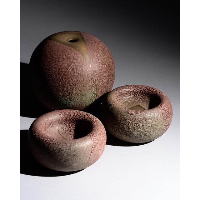 Studio ceramic trio by Mario Enke, consisting of one rounded vase and two matching bowls in hand-thrown terracotta with a...