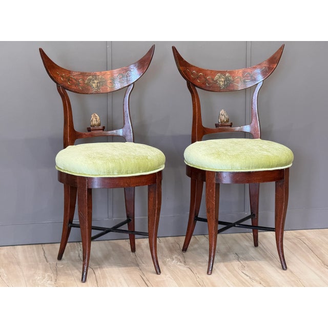 Pair of early 19th century German Beidermeier side chairs featuring curved crest rails painted with stylized female masks...
