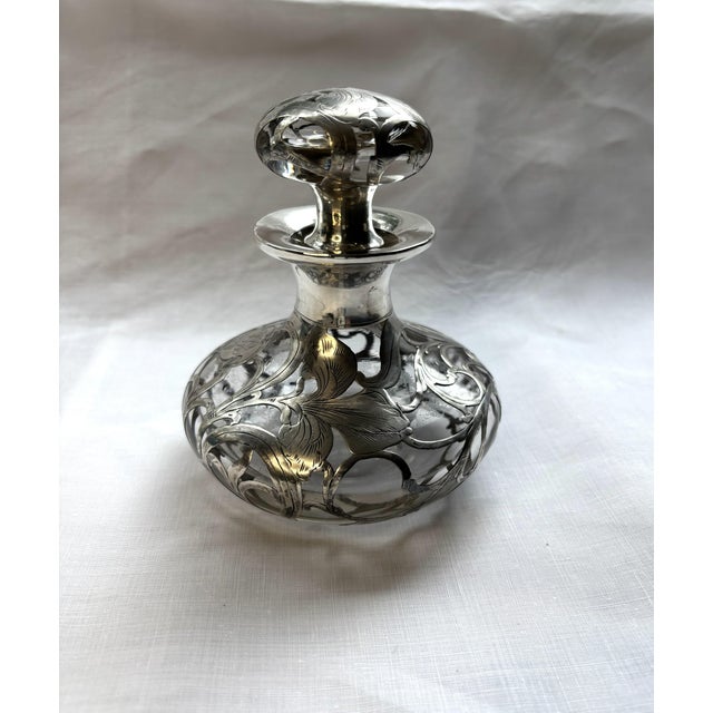 This Art Nouveau-style silver overlay glass bottle was produced in the late 19th century by the luxury American brand...