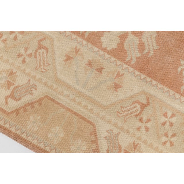 This is a vintage Turkish Oushak rug from the Mid 20th Century. The piece was hand-knotted.