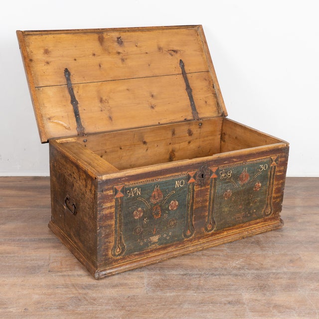 Dated 1830, this 19th-century pine trunk retains its original hand-painted folk art finish. The exterior features a soft...