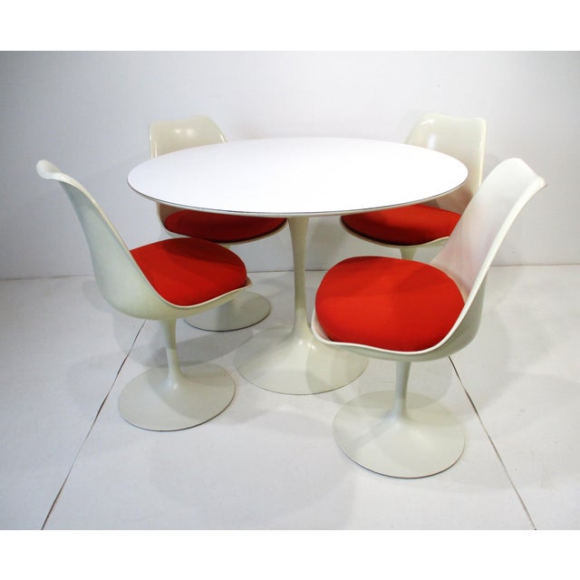 A very well crafted and iconic Mid Century white tulip table with four matching swiveling side chairs reupholstered in red...