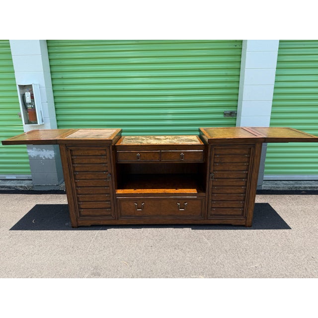 Authentic Marge Carson-Versatile wooden sideboard has a central marble top and two flip-top side panels with textured...