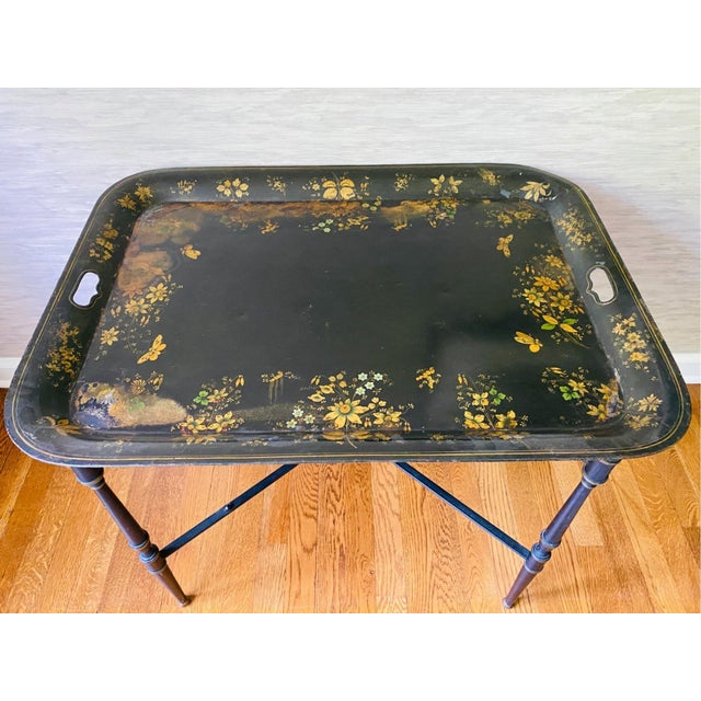 A vintage Italian ebonized coffee table with a removable tole tray decorated in with floral and butterfly motif and a...