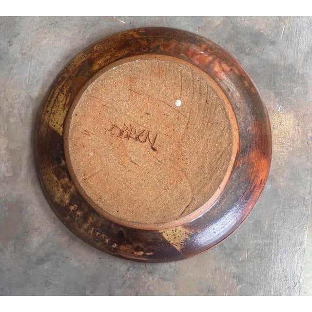 Vintage studio pottery bowl featuring a rich rust, ochre and brown glazed surface with expressive abstract linework and...