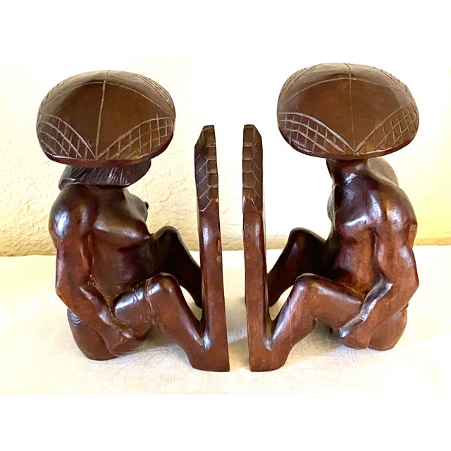 Mid Century pair of beautifully hand carved wood bookends of a tribal man and woman, with a rich brown sheen, probably...