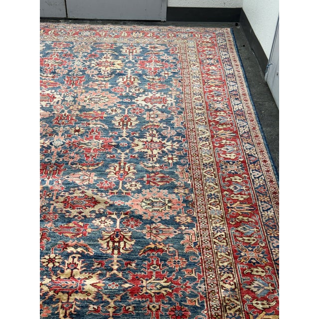 Design Plus Gallery presents a 9ft 3in × 12ft Hand Knotted Persian Wool Area Rug. A lively blend of reds, blues, and ivory...