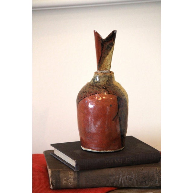 This unique piece is hand-made and one-of-a-kind! It consists of an earthenware bottle with a geometrically abstract...