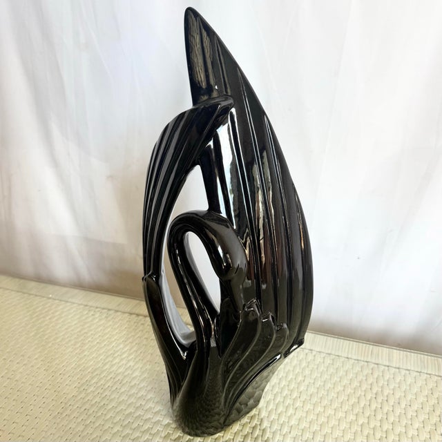 A striking vintage Art Deco ceramic sculpture by Haeger, finished in a deep glossy black glaze. This elegant swan form...
