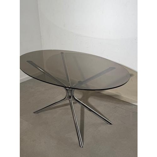 Stunning 1960s vintage dining table featuring a sleek chrome base combined with an elegant smoked glass top. This mid-...