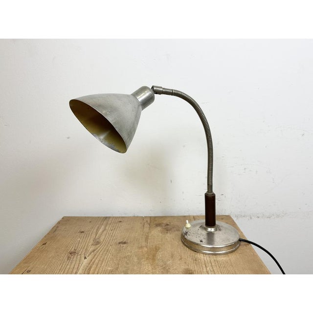 Vintage industrial adjustable table lamp made in former Czechoslovakia during the 1950s It features an aluminium shade and...
