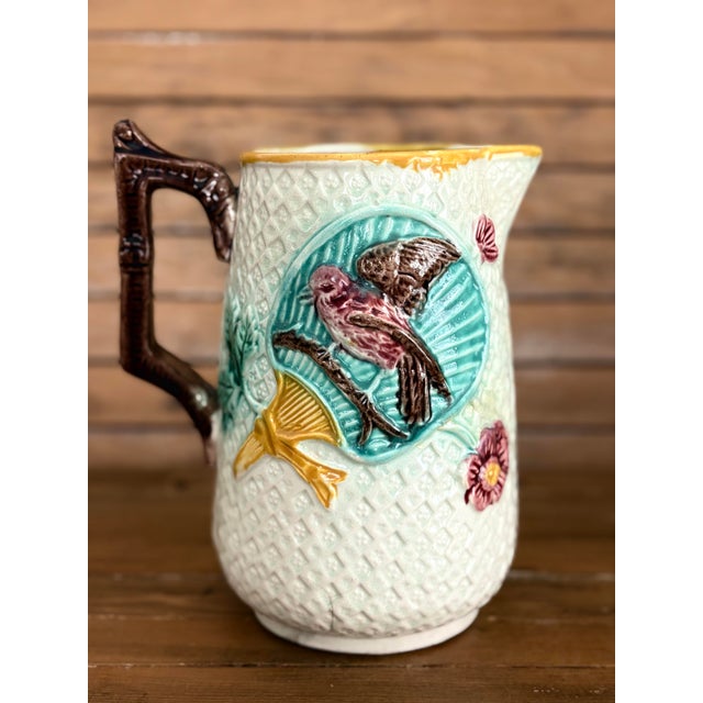 Antique Victorian English majolica pitcher with a wonderful raised bird motif. The body is decorated with a diamond...
