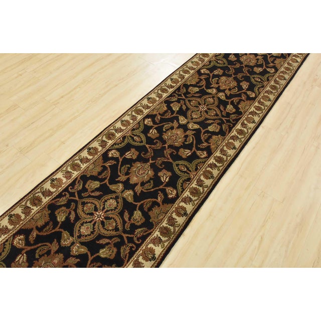 A traditional Agra runner hand-knotted with an all-wool pile on a cotton foundation. This finely woven oriental rug...