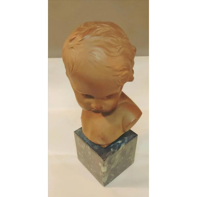 DETAILS... Signed petite french bust of a child in the manner of Jean Antoine Houdon. This figural sculpture of a young...