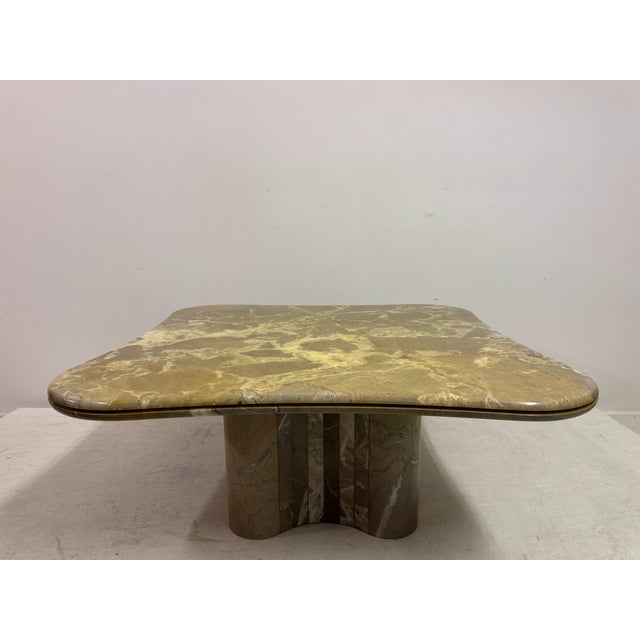 A sculptural marble coffee table from the 1970s, distinguished by its softly undulating square top and bold architectural...