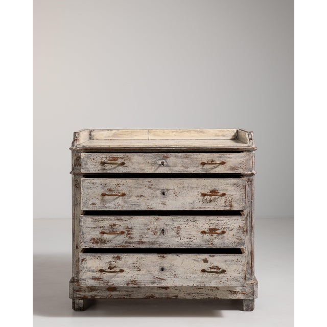 A charming chest of drawers with a distressed painted finish, reflecting the layered aesthetic now associated with “shabby...