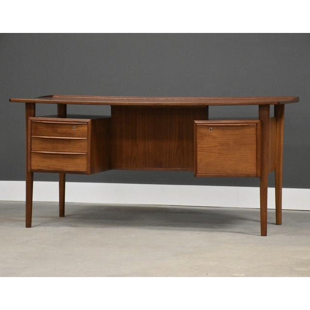 A mid century modern teak floating top desk designed by Peter Løvig Nielsen with a drawer with the capability for hanging...