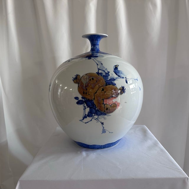 The John-Richard Yori Global Bazaar Pomegranate Motif Round Porcelain Vase is a decorative home accessory, often listed...