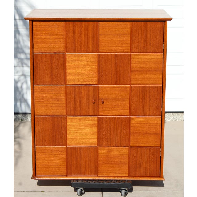 A striking combination of Mid-Century Modern design, warm teak craftsmanship, and ingenious hidden functionality, this...