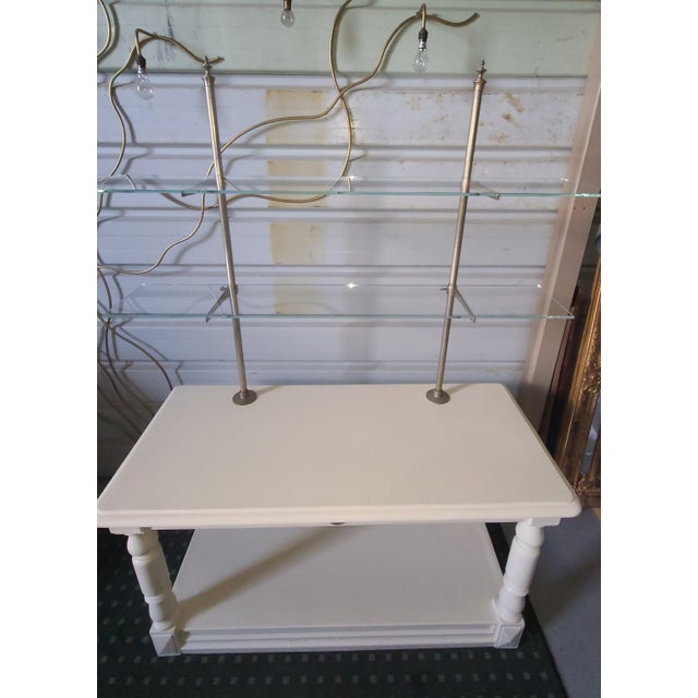 A vintage shop cabinet with two 8mm shelves and a lower shelf, originally designed for various businesses in the early...