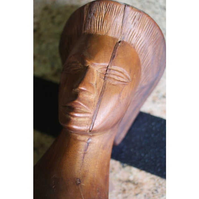 Wooden sculpture of a head on a pedestal. Carved wood that is probably teak or rosewood. Wonderful details. Sliver of wood...