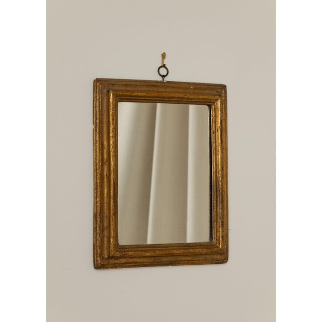 A small vintage Italian Borghese giltwood wall mirror, mid 20th century. The frame features a simple stepped wood profile,...