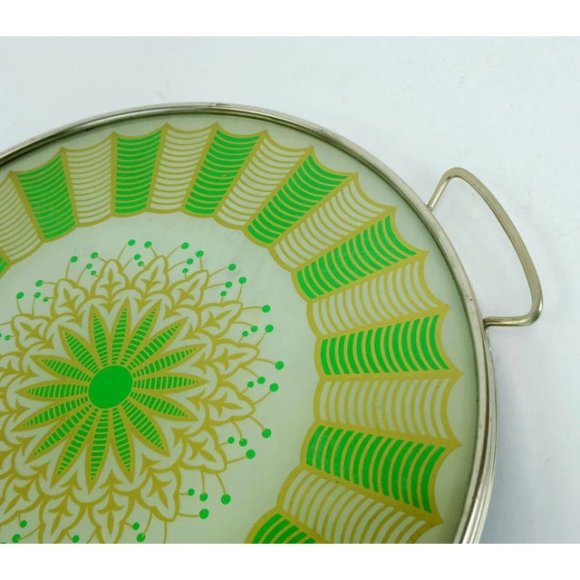 Beautiful old round tray from the 20s/30s. The surface is made of glass and has an abstract back glass decor. The basic...