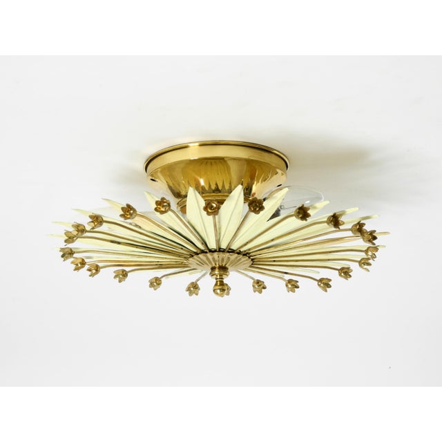 A stunningly beautiful small mid-century sunburst wall or ceiling lamp. Made in germany. the star-shaped lampshade is made...