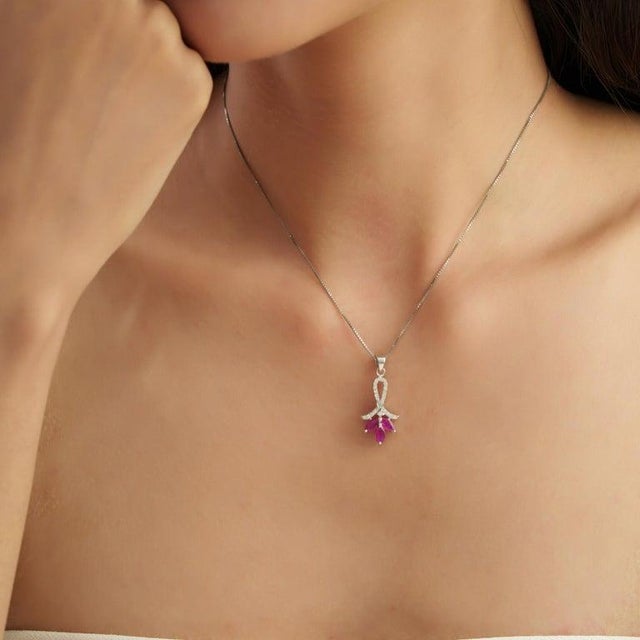 Crafted in 925 sterling silver, this elegant floral pendant features 0.86 carats of marquise-cut natural rubies accented...