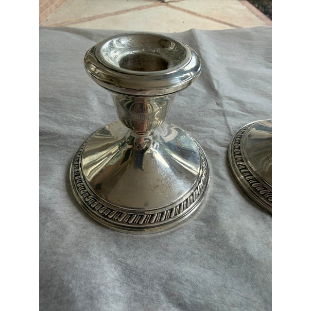 A classic pair of vintage weighted sterling silver candlesticks featuring an elegant, understated design with finely...