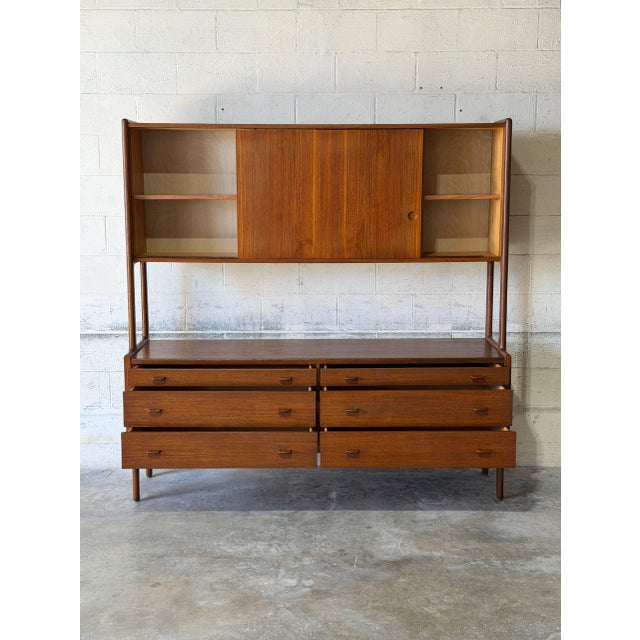 This impressive two-piece unit features a spacious six-drawer base beneath a sleek hutch with smooth sliding doors. The...