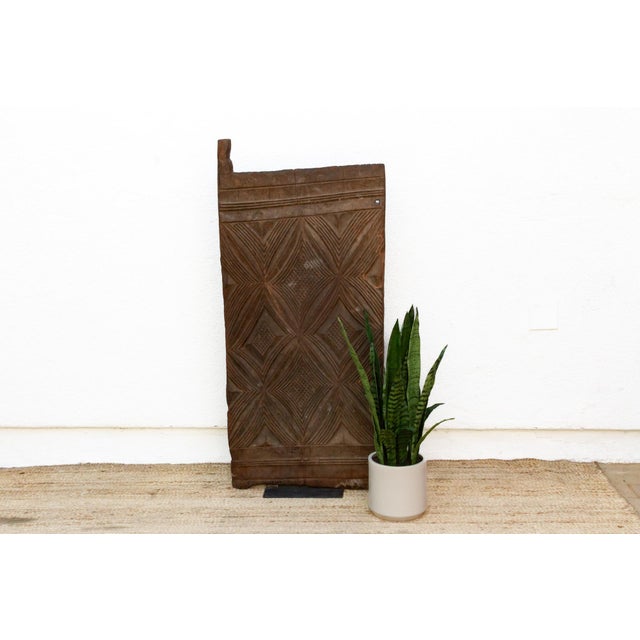Hand-carved from a single plank of hardwood, this door presents a bolder, more sculptural read of Mali's Dogon and Bamana...