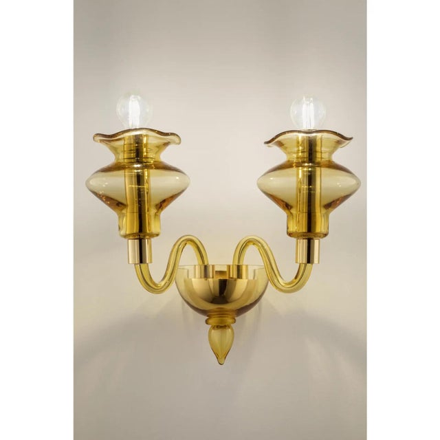 Elegant italian wall sconce in amber made in murano glass and gold plated metal frame. for classical and modern interiors,...