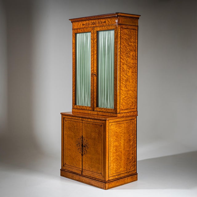 Very tall yet relatively narrow display cabinet with a two-door lower section and a glazed two-door upper case. The piece...