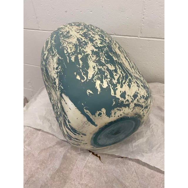 A glass vase in a soft powder blue is enhanced with an overlay of silver mercury.