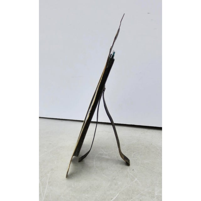 Antique English photo frame. Cut-out brass with inscized scrolling pattern following the outer contours of the brass....