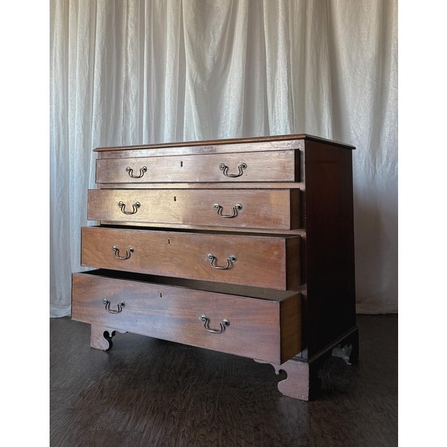 This Georgian mahogany four-drawer chest brings classic English elegance to any space with its rich mahogany finish and...