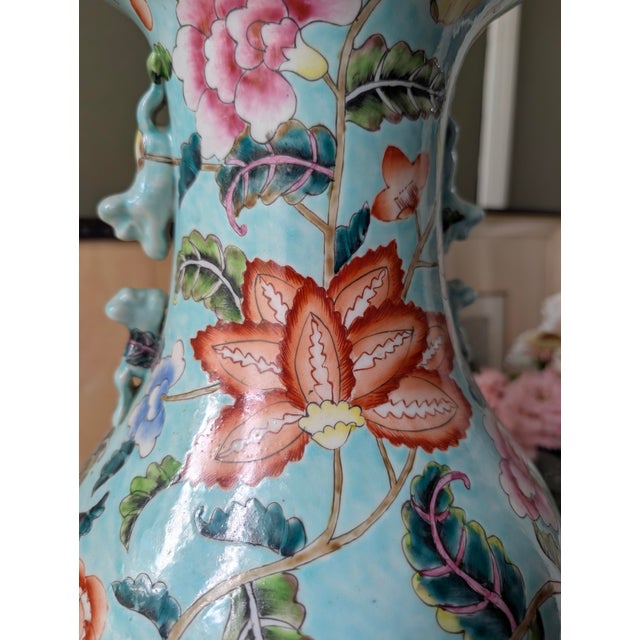 Large hand-painted porcelain floor vase featuring a pale turquoise ground with elaborate multicolor floral decoration....