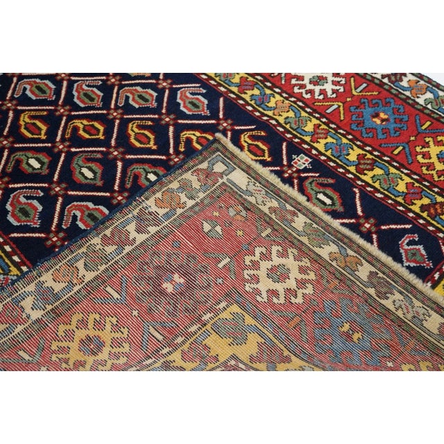 From the southern Caucasus, this good condition long piece presents a dark indigo blue field decorated with a diamond...