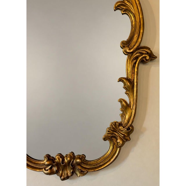 An elegant late 19th-century antique Rococo Revival gilt gesso wall mirror, distinguished by its bold, asymmetrical...