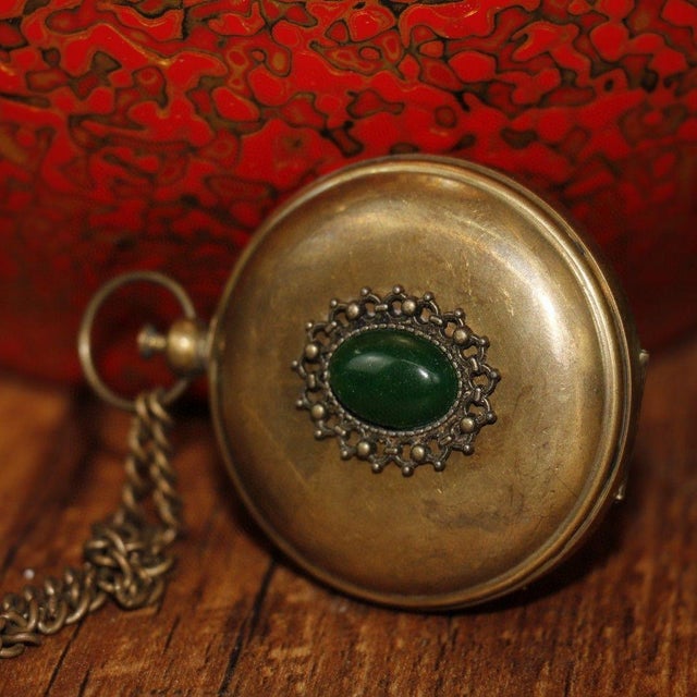 Solid brass pocket compass combining sundial and compass functions, engraved with directional markings and vintage London...