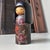 This charming vintage kokeshi is decorated with an elegant floral pattern and a graceful red bow. It was made by the...