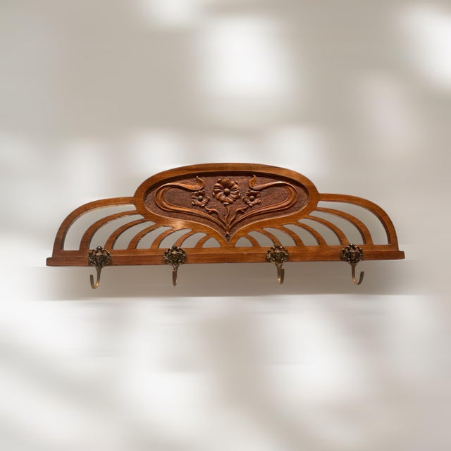 Very beautifully crafted Art Nouveau wall coat rack with 4 brass hooks and contemporary floral carving. A highlight in...