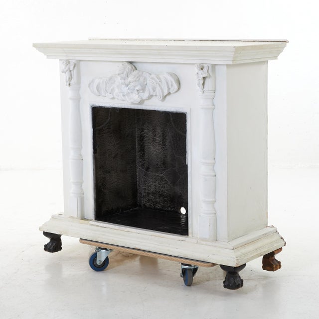 A fireplace with insert as a replica from around 1920. The piece is painted white and has a jet black interior. The decor...