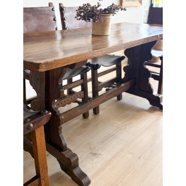 A showstopper of a piece, this antique French dining table features a fruitwood top set over an oak and ash trestle base....