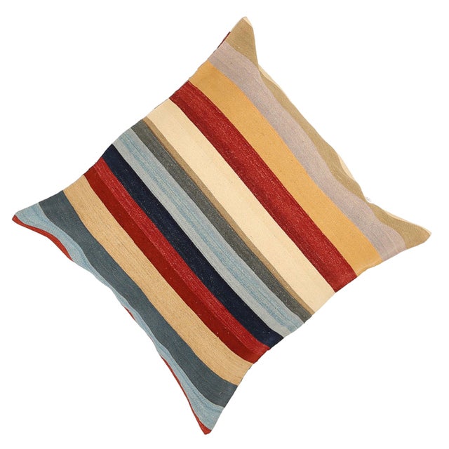A one-of-a-kind handwoven wool kilim floor pillow featuring bold horizontal bands of navy, red and gold. Fully reversible...