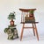 Green ceramic elephant garden stool with cream and blue accents. The elephant is wearing decorative garb with tasseled...