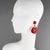 Angela Caputi, Italy, designed those stunning resin clip-on earrings. They feature an oversized, dangling, donut-like...